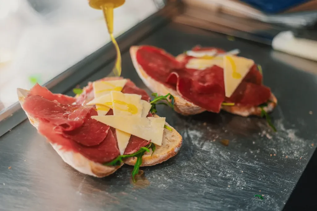 Fresh Italian sandwich with cured meat, Parmesan, rocket and olive oil being prepared at Little Italy York