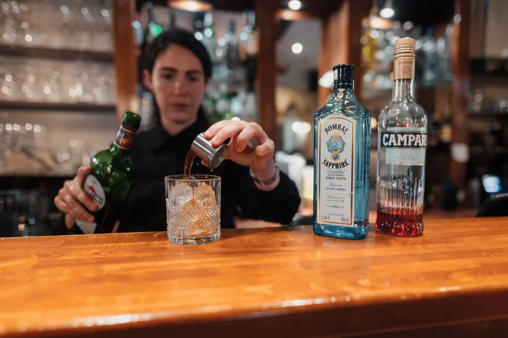 Bartender preparing a handcrafted cocktail behind the bar at Little Italy in York