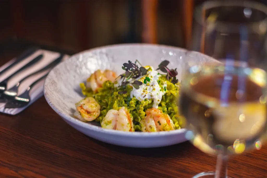 Homemade seafood pasta with king prawns and Italian white wine at Little Italy restaurant in York