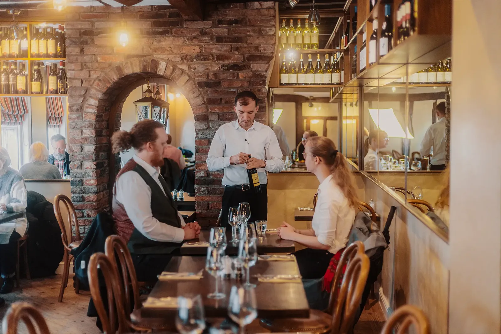 Member of staff serving Italian wine to guests at Little Italy restaurant in York