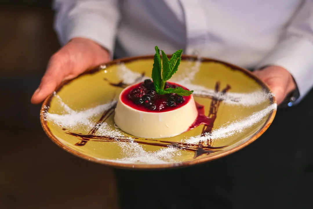 Homemade Italian panna cotta with berry compote and fresh mint served at Little Italy in York